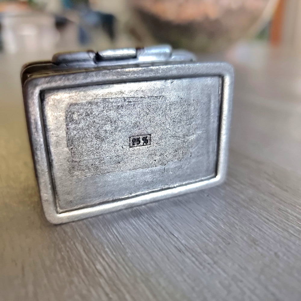 Small metal trinket box with a raised rose lid design