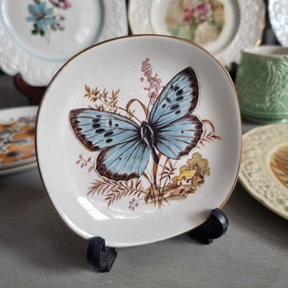 Vintage Weatherby Hanley Royal Falconware plate with a blue butterfly, brown grasses, a small cottage and a gold-toned rim