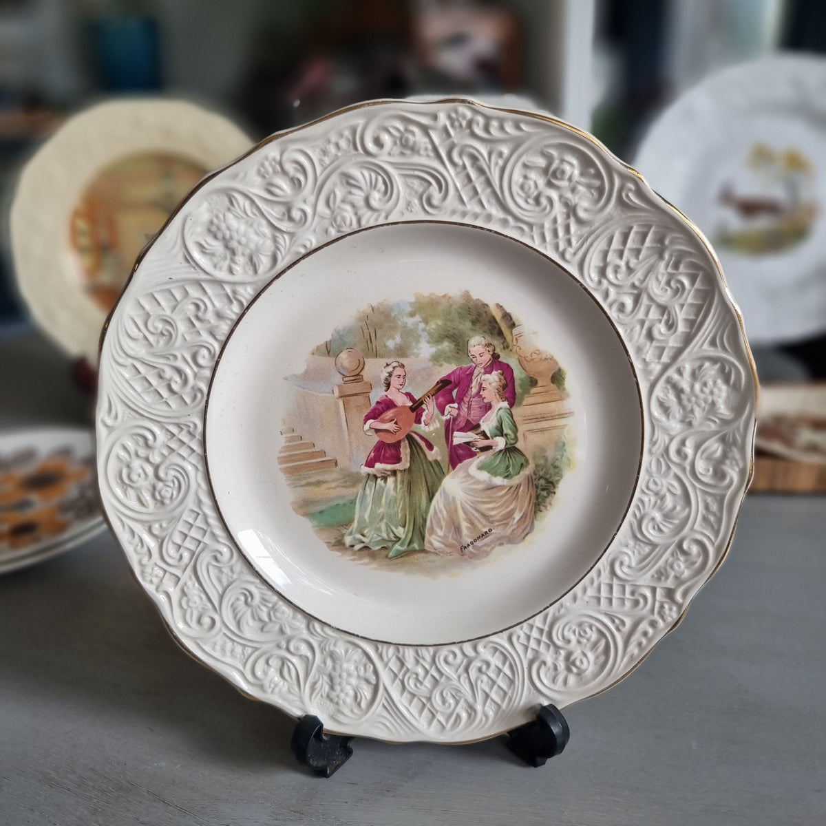 Vintage Solian Ware plate with a garden scene of three musicians in period costume and an embossed scroll border