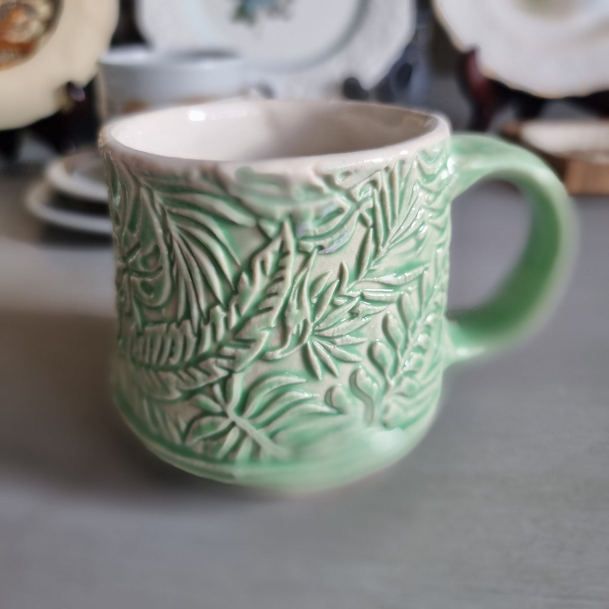 Vintage Virginia NZ made mug with a green glaze and raised fern and leaf pattern