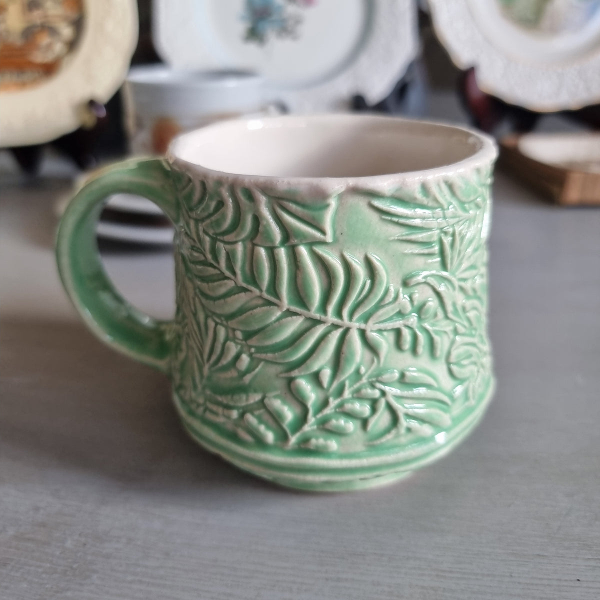 Vintage Virginia NZ made mug with a green glaze and raised fern and leaf pattern