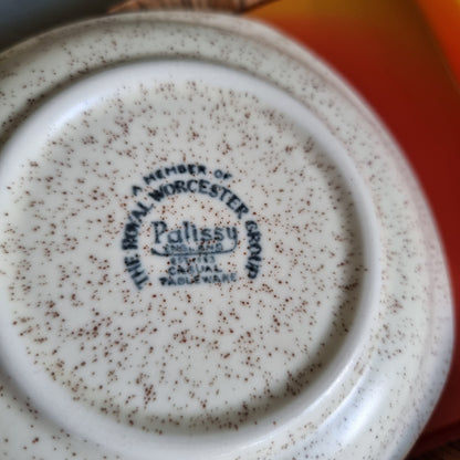 Vintage Palissy speckled plate with orange and brown flowers in a wood-look box with an orange handled knife
