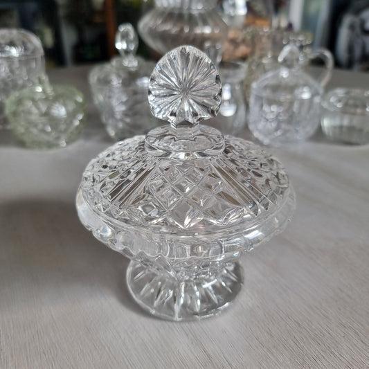 Clear cut glass lidded compote with diamond cut dome lid, fan shaped finial and pedestal foot