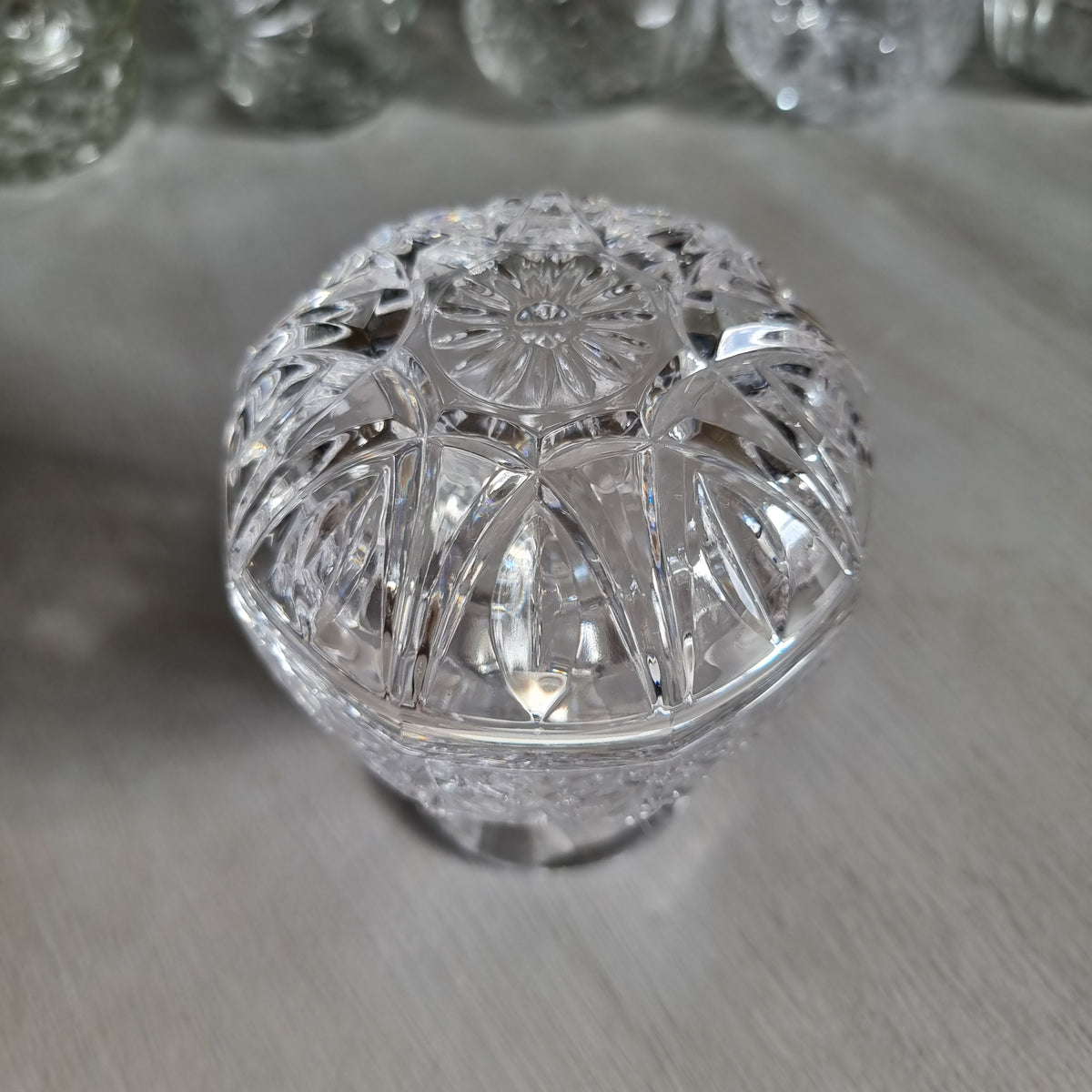 Clear cut crystal footed compote with a rounded dome lid with arched cuts and a star to the top