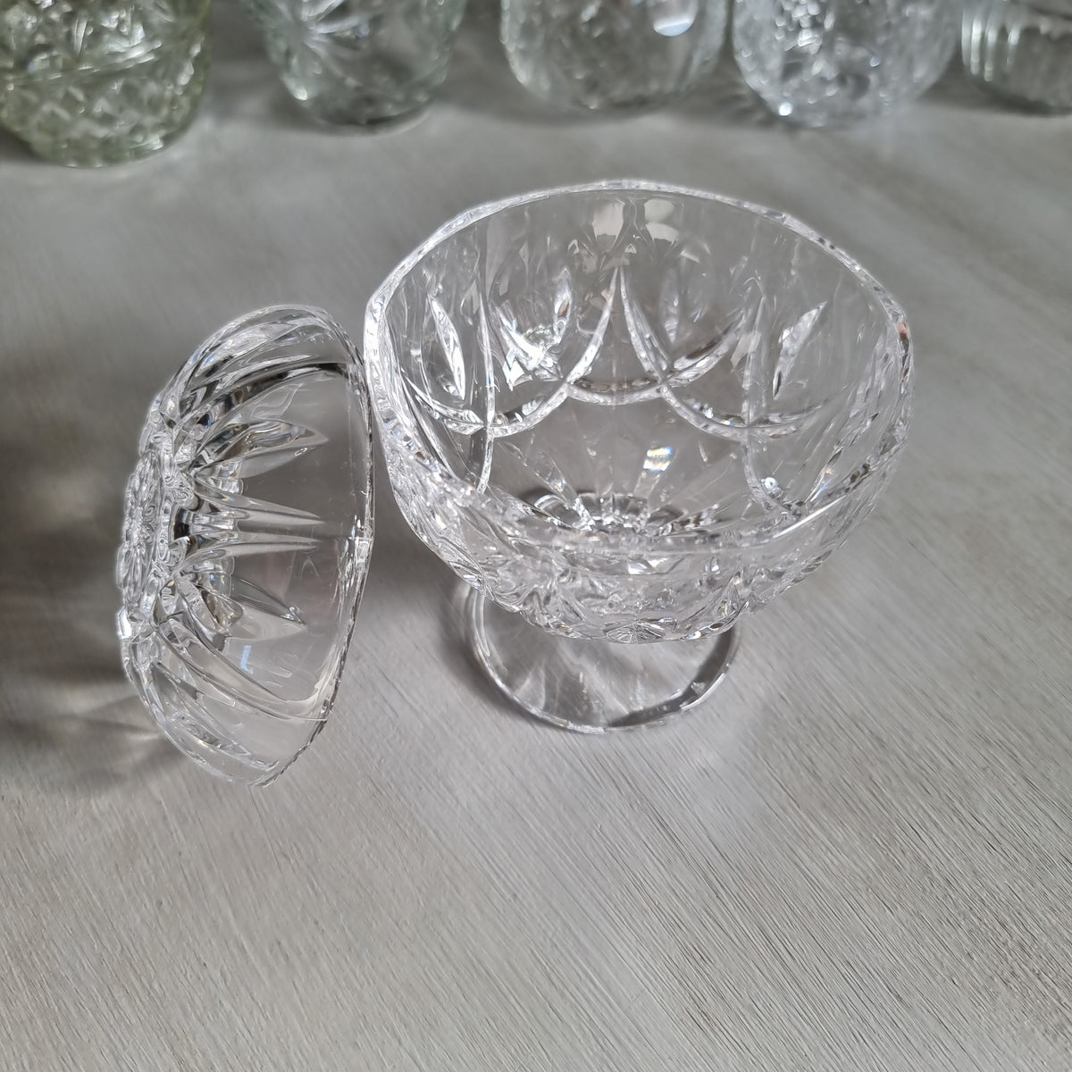 Clear cut crystal footed compote with a rounded dome lid with arched cuts and a star to the top