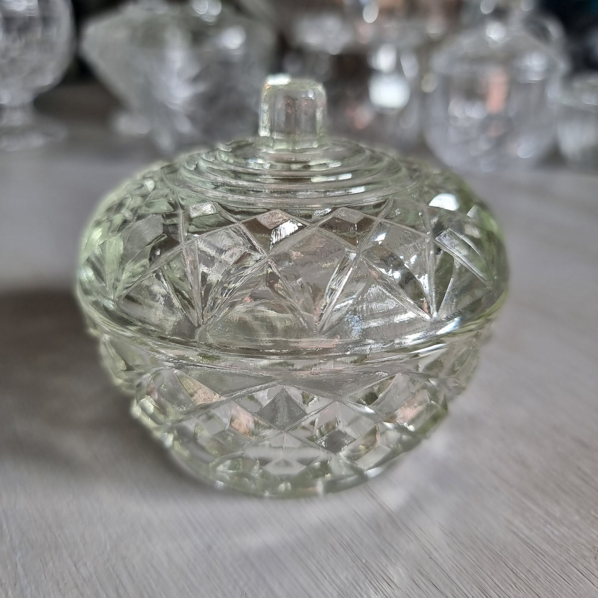 Small round clear glass lidded trinket bowl with diamond and star pattern and a knob lid