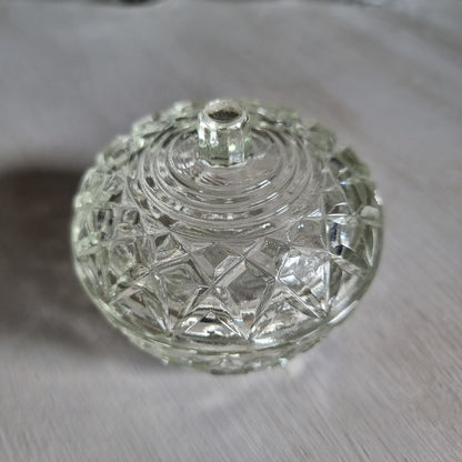 Small round clear glass lidded trinket bowl with diamond and star pattern and a knob lid