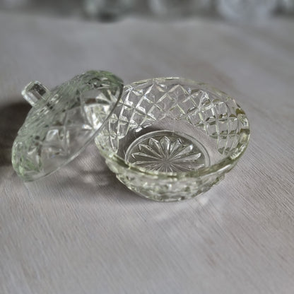 Small round clear glass lidded trinket bowl with diamond and star pattern and a knob lid