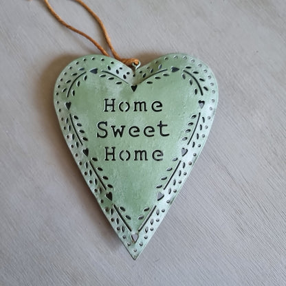 Sage green metal heart with Home Sweet Home cut out in the centre and a punched heart and leaf border, hanging from twine