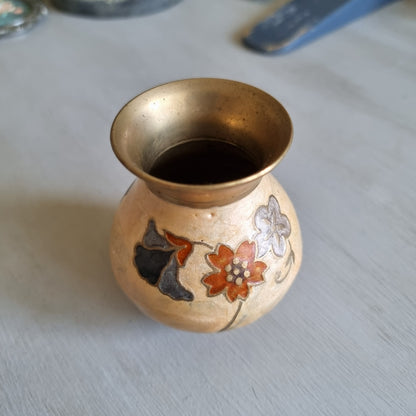 Small brass bud vase with a cream enamel body decorated with rust red, blue and grey flowers