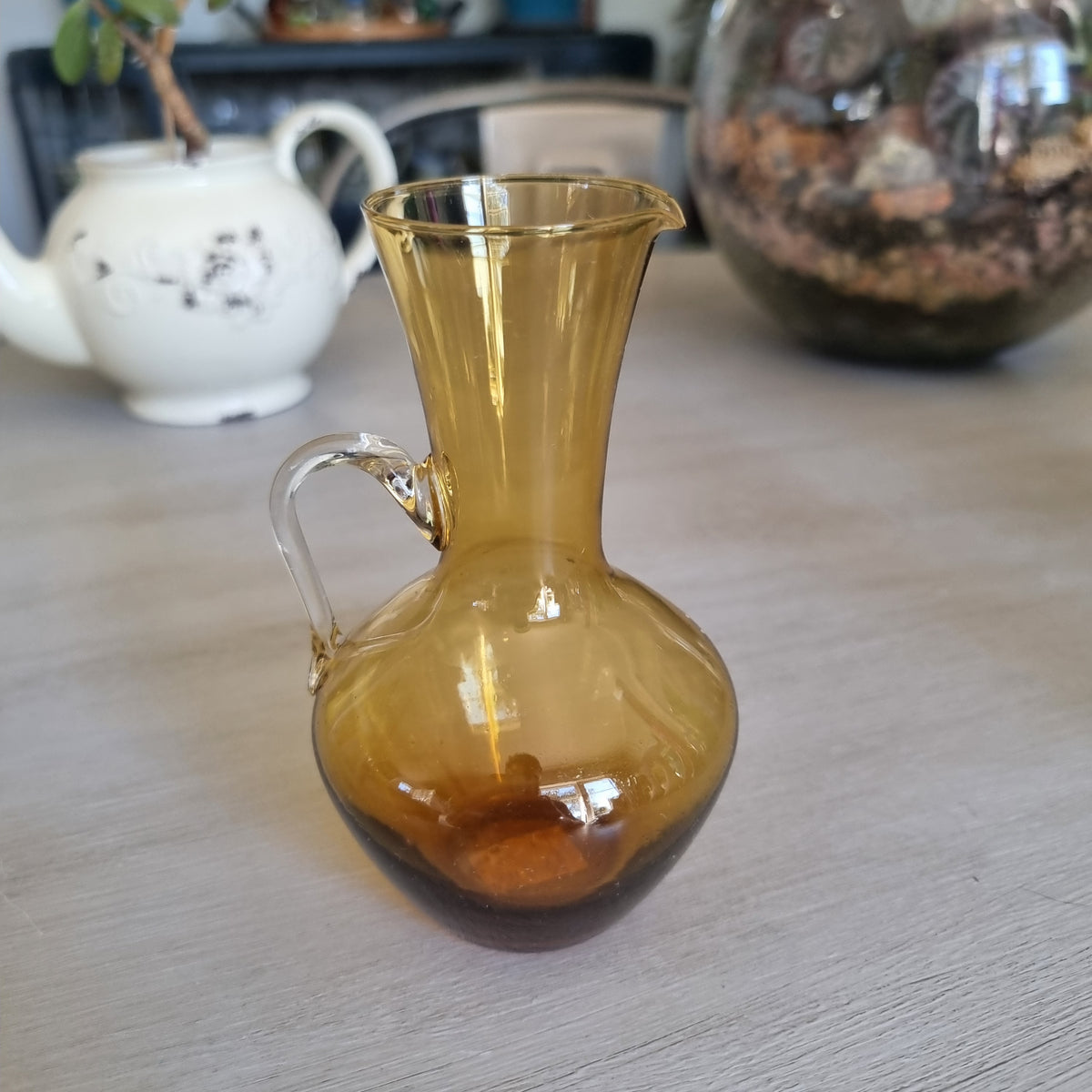 Vintage amber glass jug with a rounded body, pouring lip and clear glass handle
