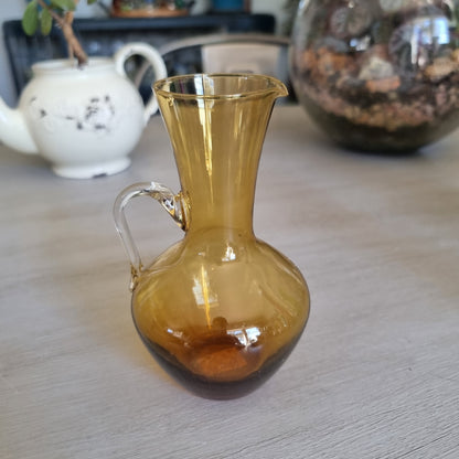 Vintage amber glass jug with a rounded body, pouring lip and clear glass handle