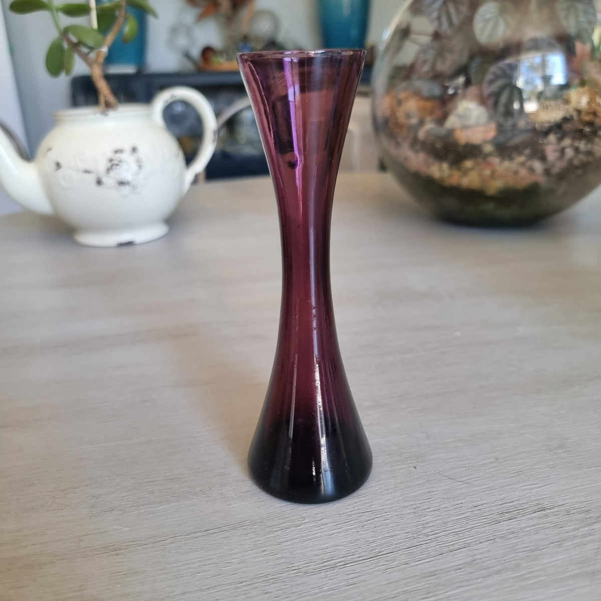 Small vintage purple glass bud vase with an hourglass shape and flared rim