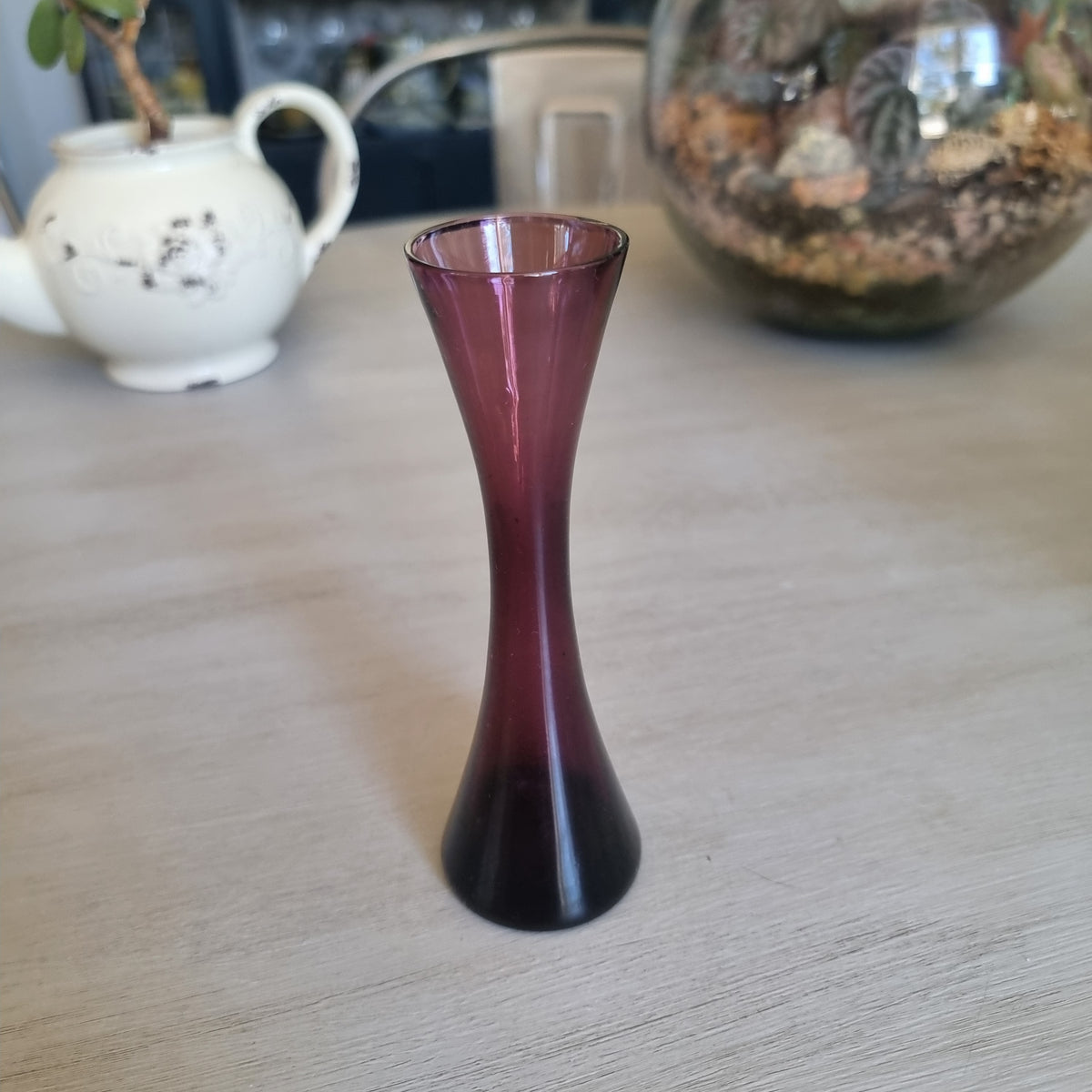 Small vintage purple glass bud vase with an hourglass shape and flared rim
