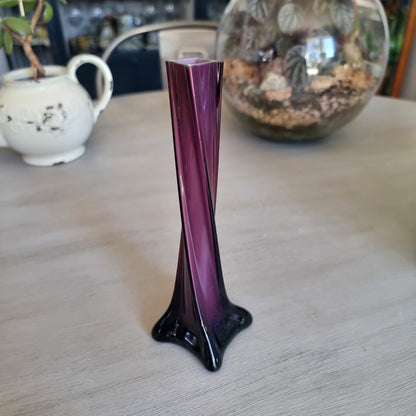 Vintage purple cased glass bud vase with white interior, twisted body and four-pointed foot