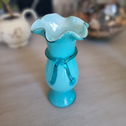 Vintage teal cased glass vase with a ruffled rim and glass ribbon tied in a bow around the neck