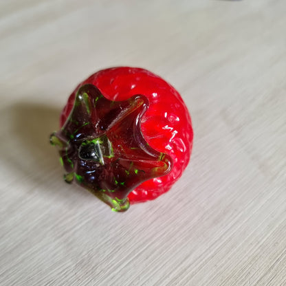 Red glass strawberry ornament with green leaves