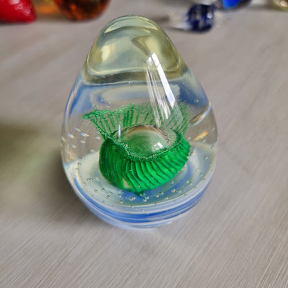 Large clear glass paperweight with blue and white swirls and green floral centre