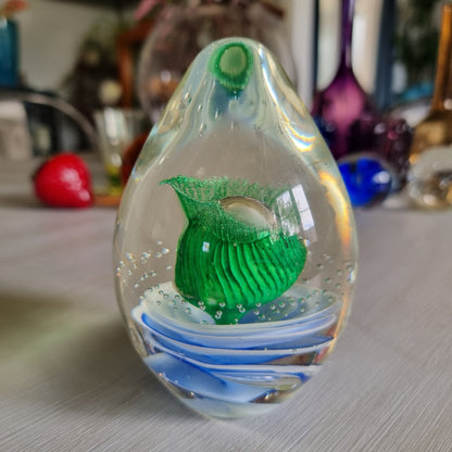 Large clear glass paperweight with blue and white swirls and green floral centre