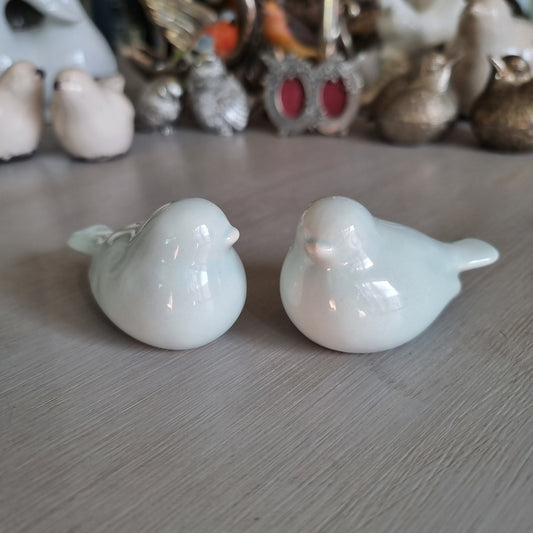 Pair of plump pale blue glazed ceramic love birds sitting side by side
