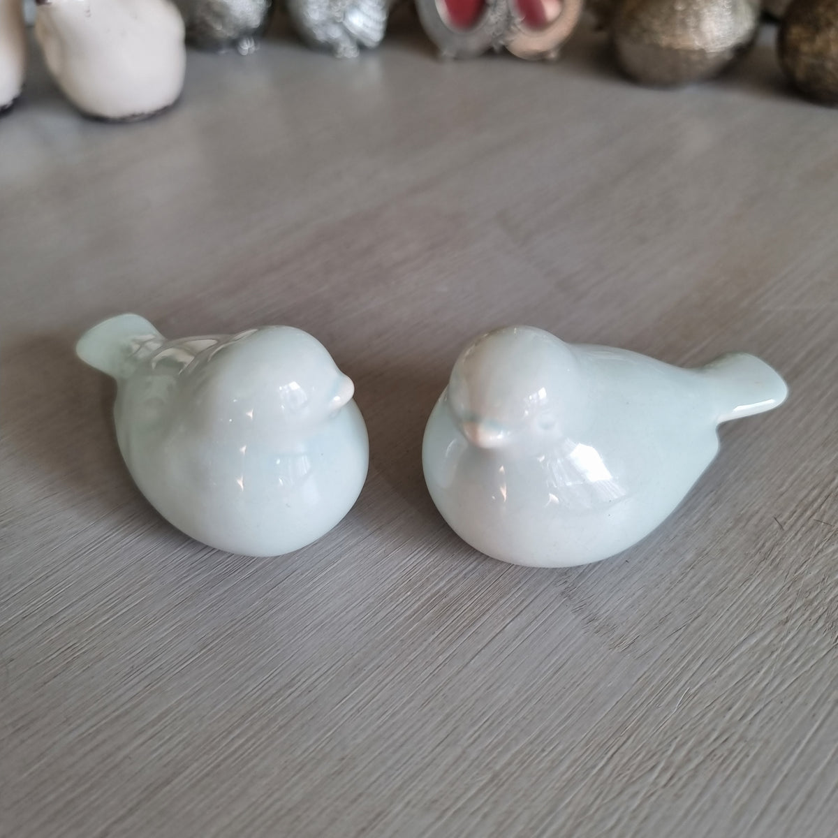 Pair of plump pale blue glazed ceramic love birds sitting side by side