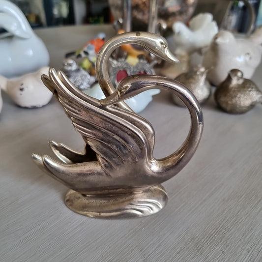 Silver swan napkin holder with sweeping feathered wings on a wave-shaped base