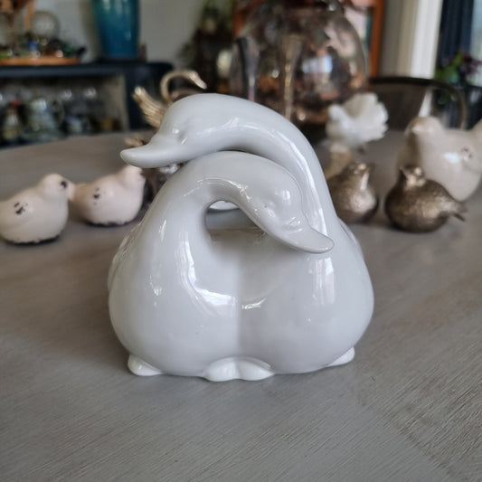 White ceramic planter shaped as two swans with entwined necks
