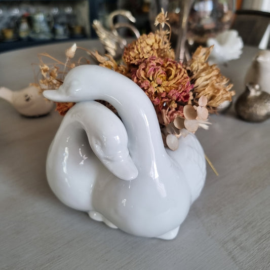 White ceramic planter shaped as two swans with entwined necks