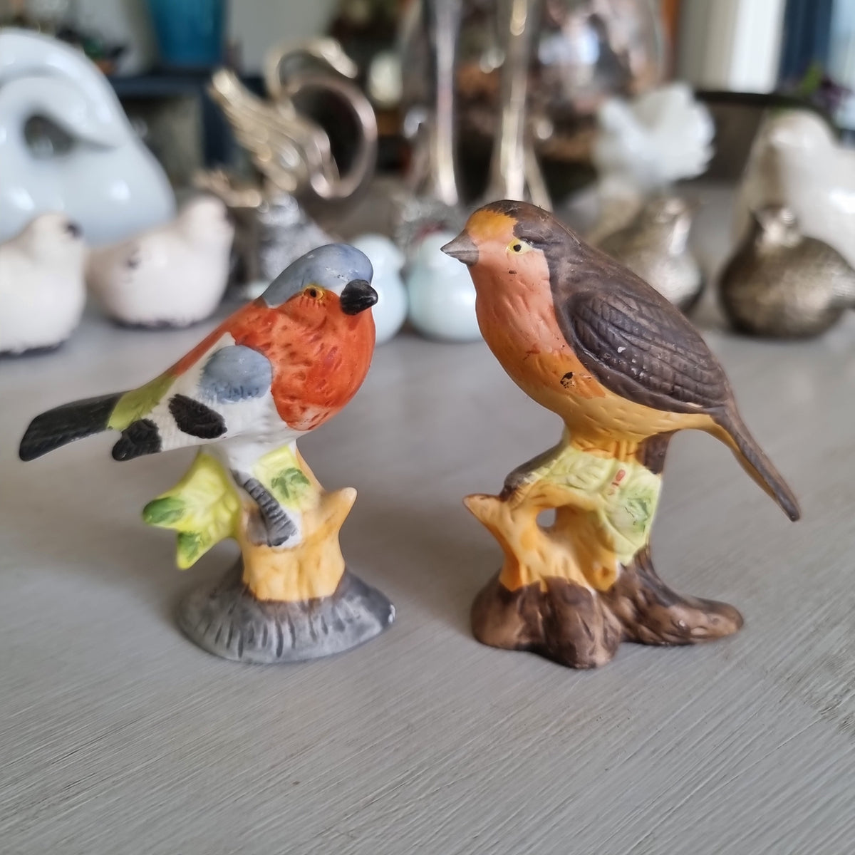 Hand-painted porcelain robin and chaffinch figurines perched on stumps