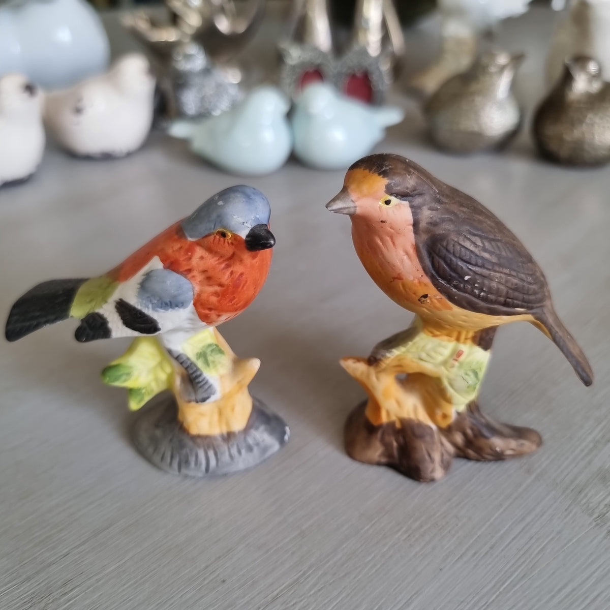 Hand-painted porcelain robin and chaffinch figurines perched on stumps