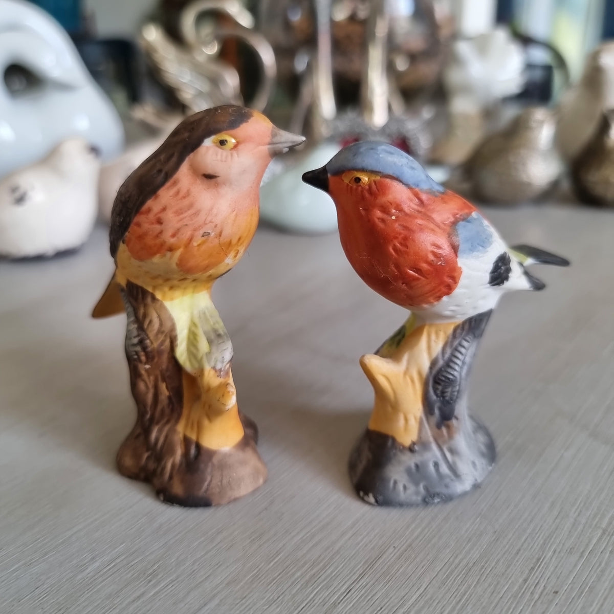 Hand-painted porcelain robin and chaffinch figurines perched on stumps